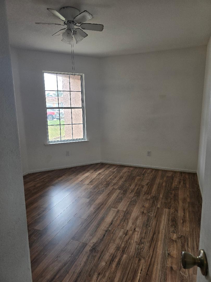 29124 Rio Verde Drive Gustine, CA 95322 - Photo 18 of 19 an empty room with wooden floor chandelier and windows