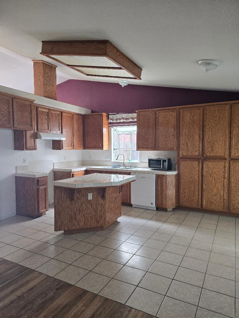 29124 Rio Verde Drive Gustine, CA 95322 - Photo 6 of 19 a kitchen with stainless steel appliances granite countertop a sink counter space cabinets and a large window