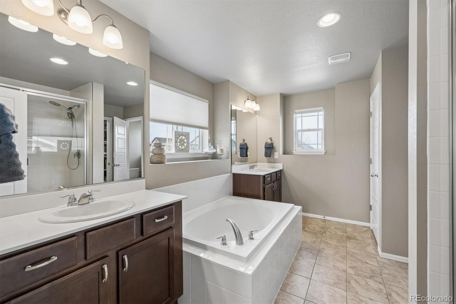 8809 Foxfire Street Firestone, CO 80504 - Photo 17 of 40 a spacious bathroom with a tub sink and mirror