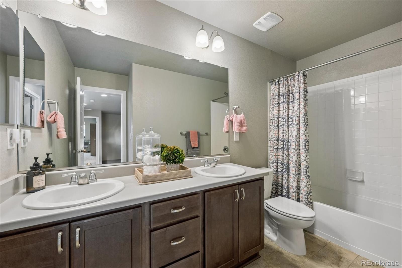 8809 Foxfire Street Firestone, CO 80504 - Photo 19 of 40 a bathroom with a double vanity sink toilet and a mirror