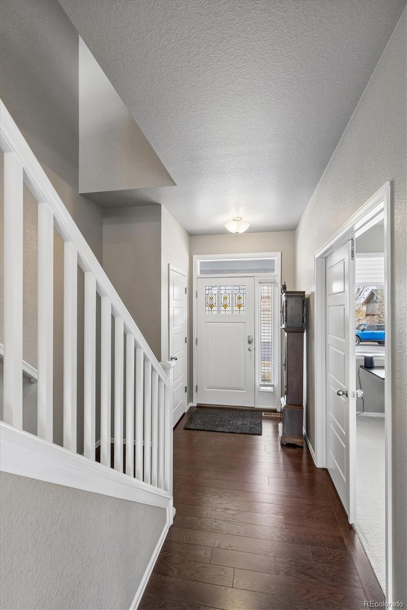 8809 Foxfire Street Firestone, CO 80504 - Photo 21 of 40 a view of a hallway with wooden floor and stairs