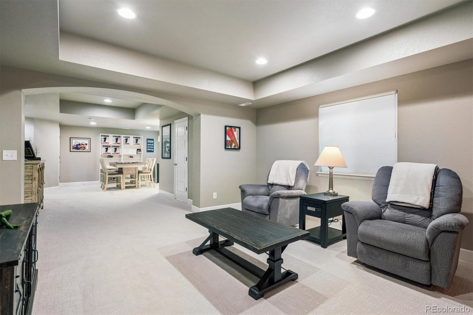 8809 Foxfire Street Firestone, CO 80504 - Photo 24 of 40 a living room with furniture a table and kitchen view