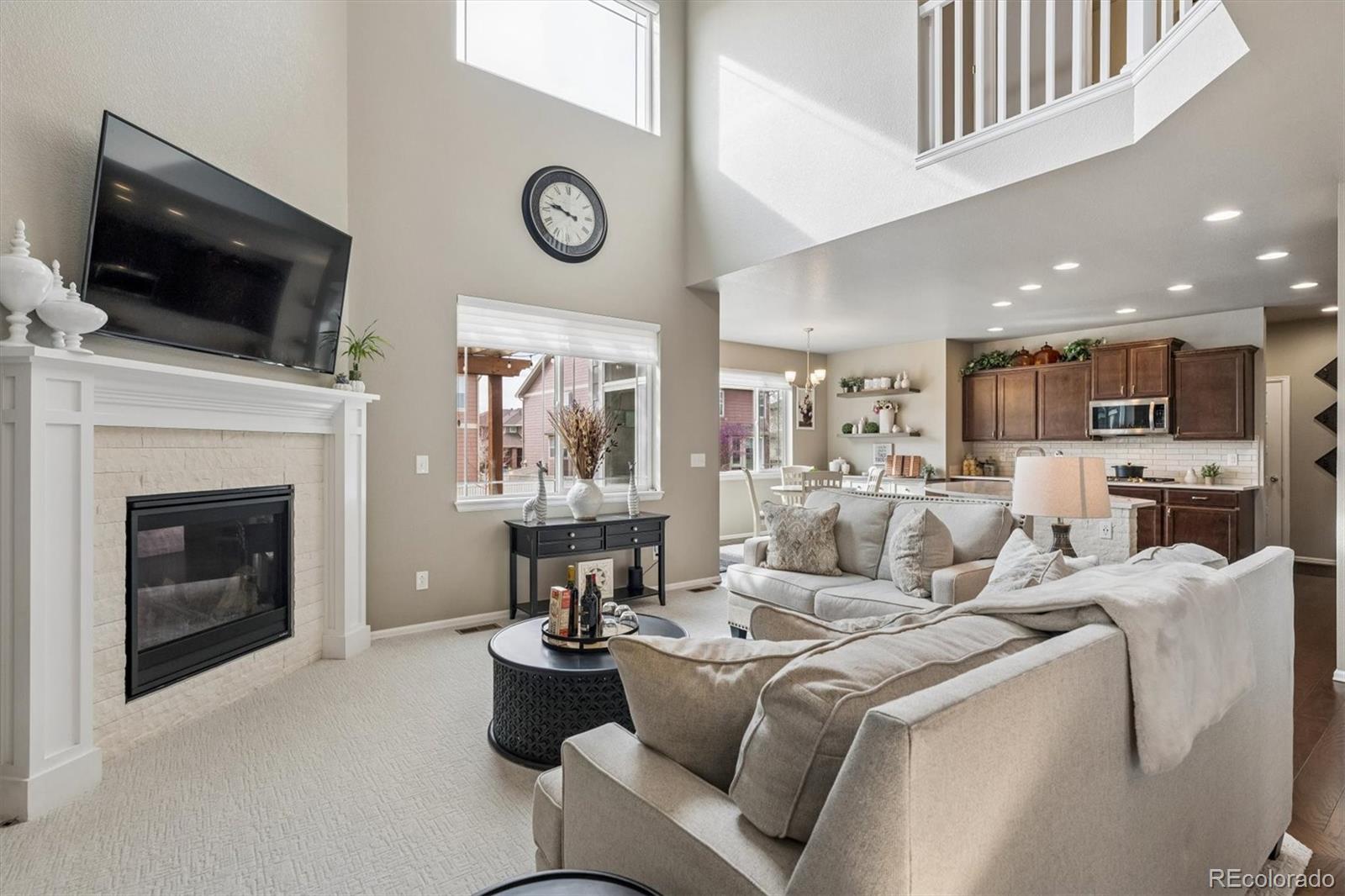 8809 Foxfire Street Firestone, CO 80504 - Photo 7 of 40 a living room with furniture a flat screen tv and a fireplace