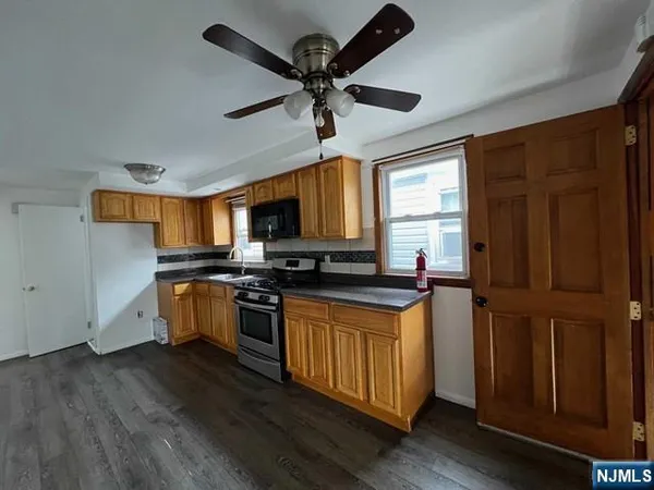 a kitchen with stainless steel appliances granite countertop wooden floors and white cabinets