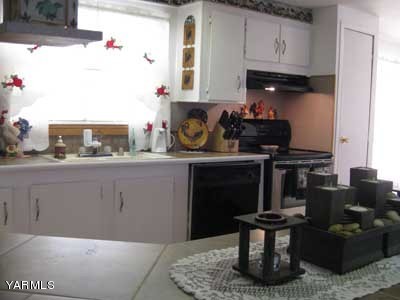 181 Schut Road, Unit 8 Moxee, WA 98936 - Photo 5 of 20 a kitchen with stainless steel appliances kitchen island granite countertop a stove a sink and a microwave
