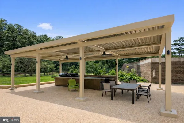 a patio with a table and chairs and potted plants