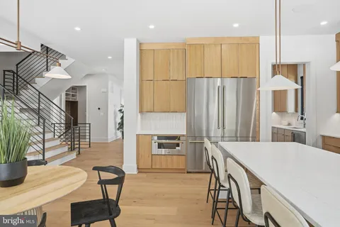 a large kitchen with kitchen island a large counter top space appliances and a living room view