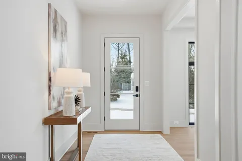 a view of a hallway with front door and wooden floor