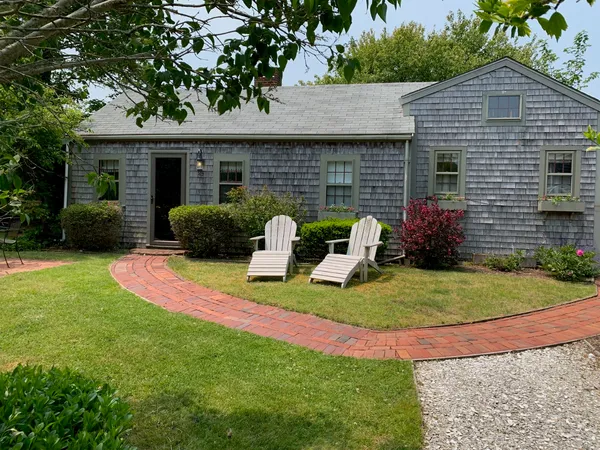 a view of a house with backyard and sitting area