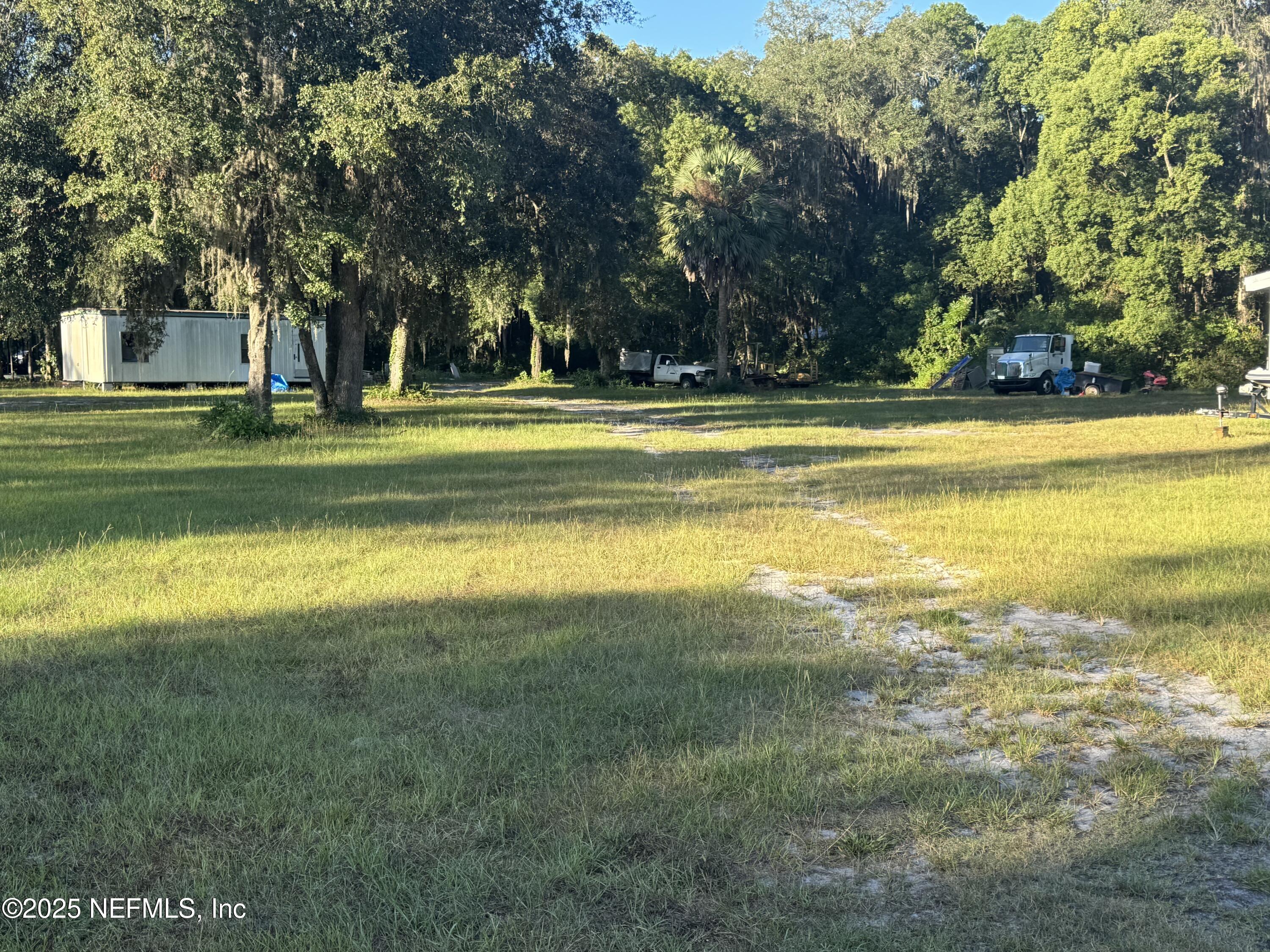 301 Northeast US Highway 301 Waldo, FL 32694 - Photo 13 of 56 a view of swimming pool with lawn chairs and large trees