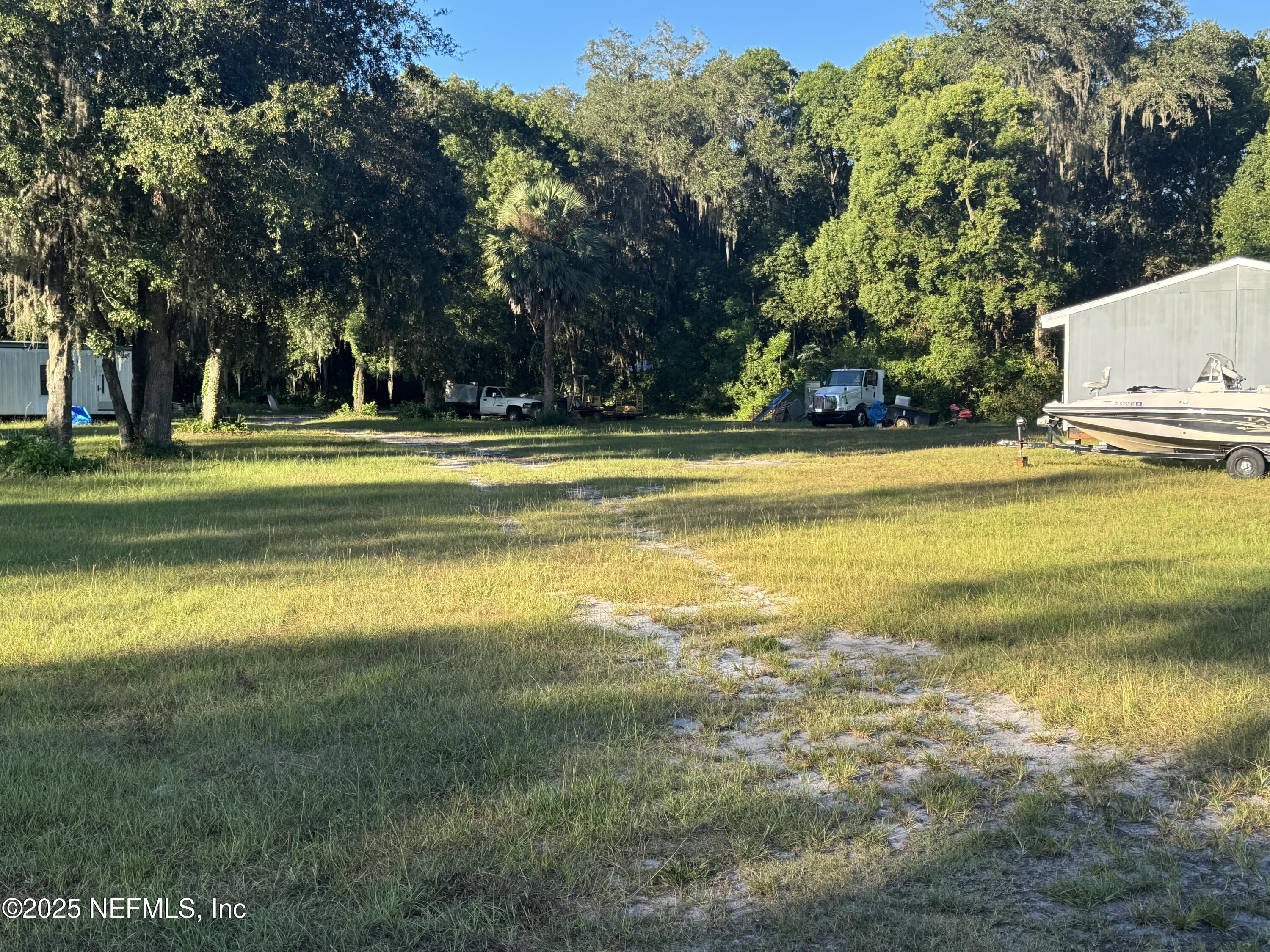 301 Northeast US Highway 301 Waldo, FL 32694 - Photo 21 of 56 a view of a swimming pool and trees in the background