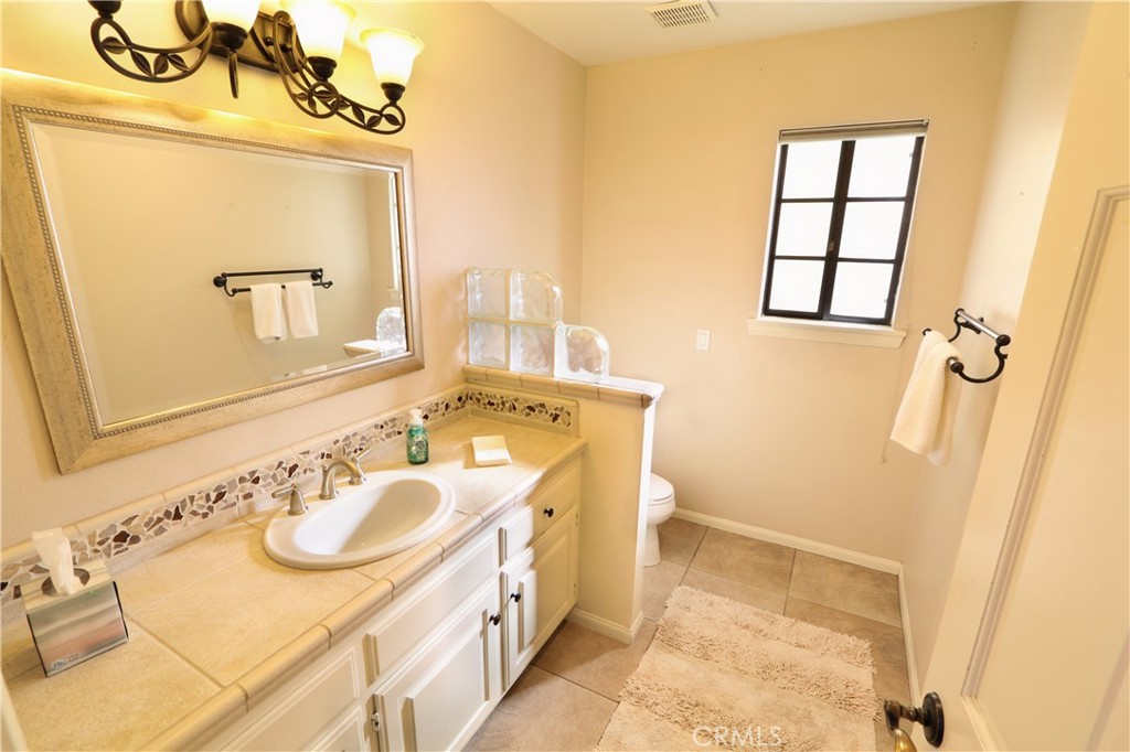 12885 Rain Shadow Road Victorville, CA 92395 - Photo 8 of 26 a bathroom with a sink vanity granite and a mirror