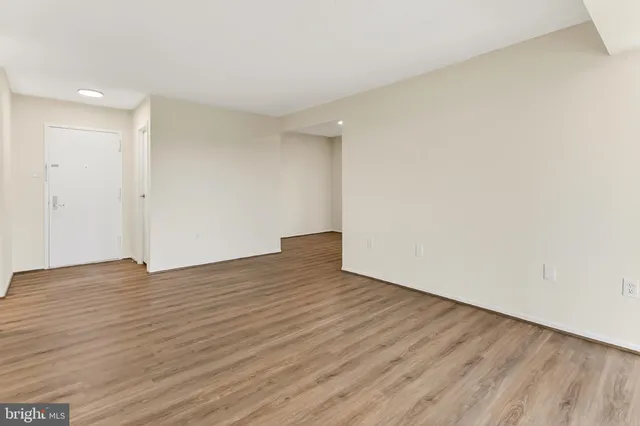 a view of an empty room with wooden floor