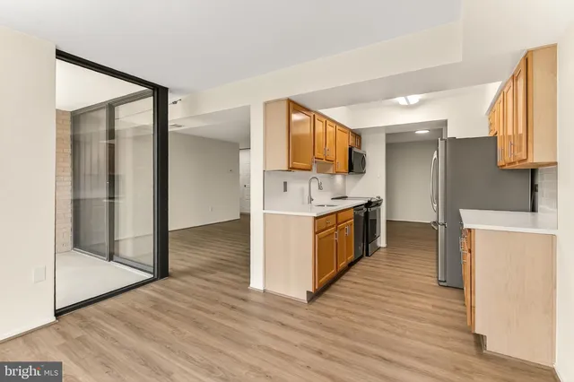 a view of kitchen with stainless steel appliances granite countertop a stove top oven a sink and a refrigerator
