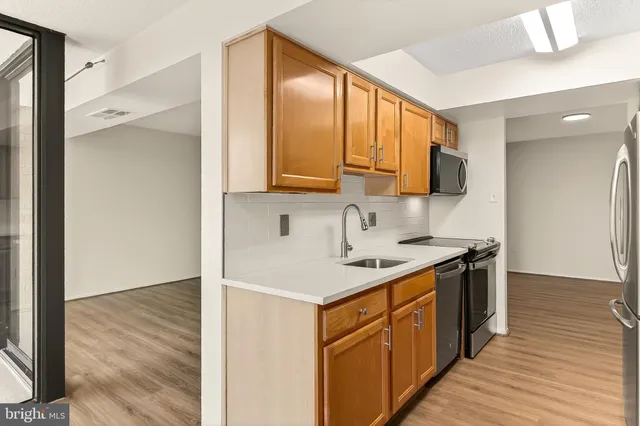 a kitchen with a sink stove top oven and cabinets
