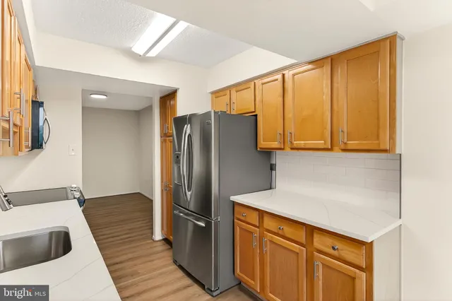 a kitchen with stainless steel appliances granite countertop a refrigerator and a sink
