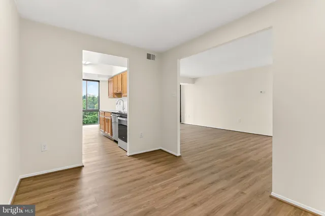 a view of a kitchen with wooden floor and a refrigerator