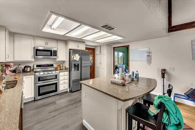 a kitchen with kitchen island a sink stove and refrigerator