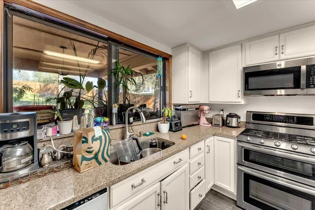 a kitchen with a stove a sink and a microwave