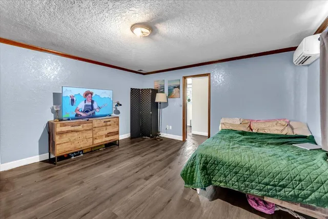 a view of a room with gym equipment and wooden floor
