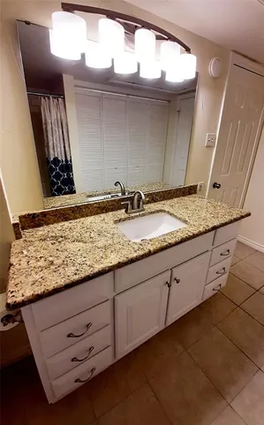a bathroom with a granite countertop sink and a mirror