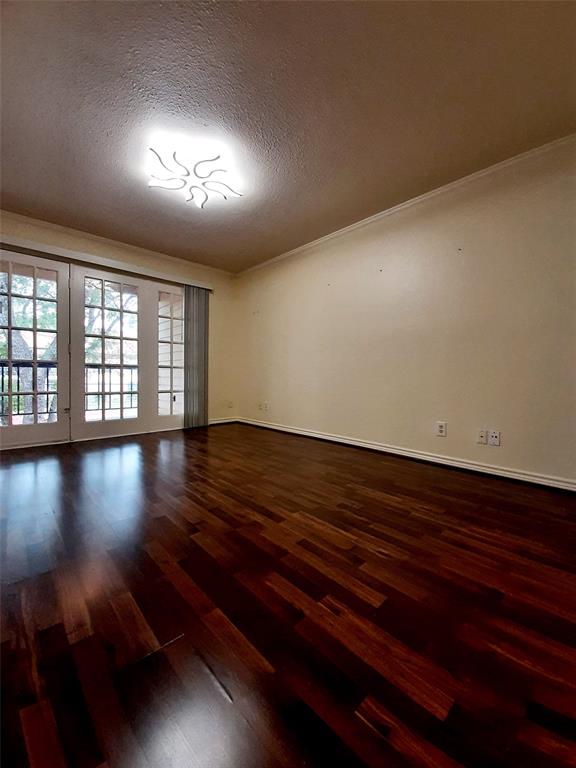 16301 Ledgemont Lane, Unit 207 Addison, TX 75001 - Photo 4 of 14 an empty room with wooden floor and windows