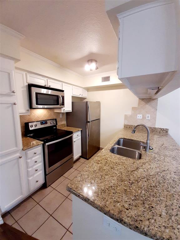 16301 Ledgemont Lane, Unit 207 Addison, TX 75001 - Photo 5 of 14 a kitchen with stainless steel appliances granite countertop a sink stove and refrigerator