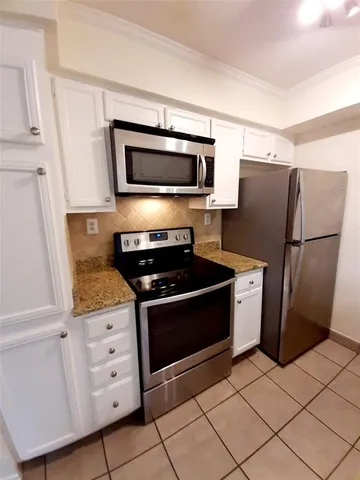 a kitchen with granite countertop a refrigerator and a stove