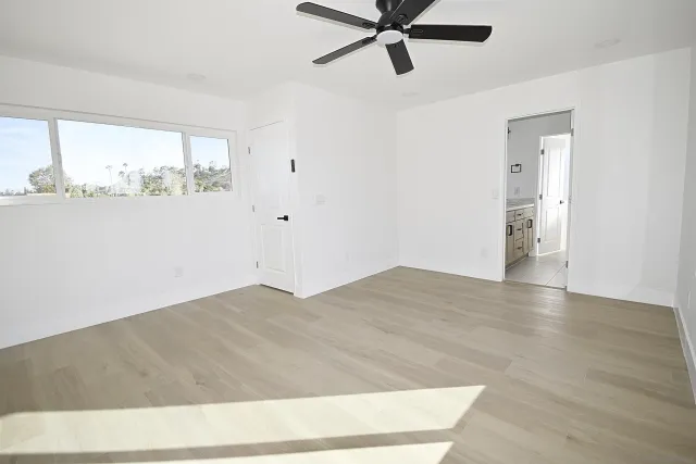 a view of a big room with wooden floor and windows