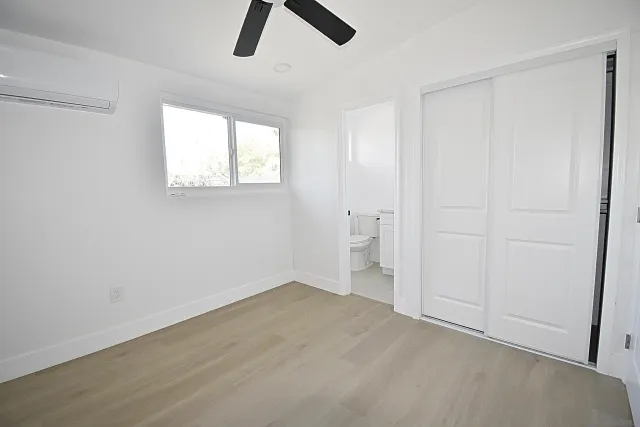 an empty room with a window and a ceiling fan