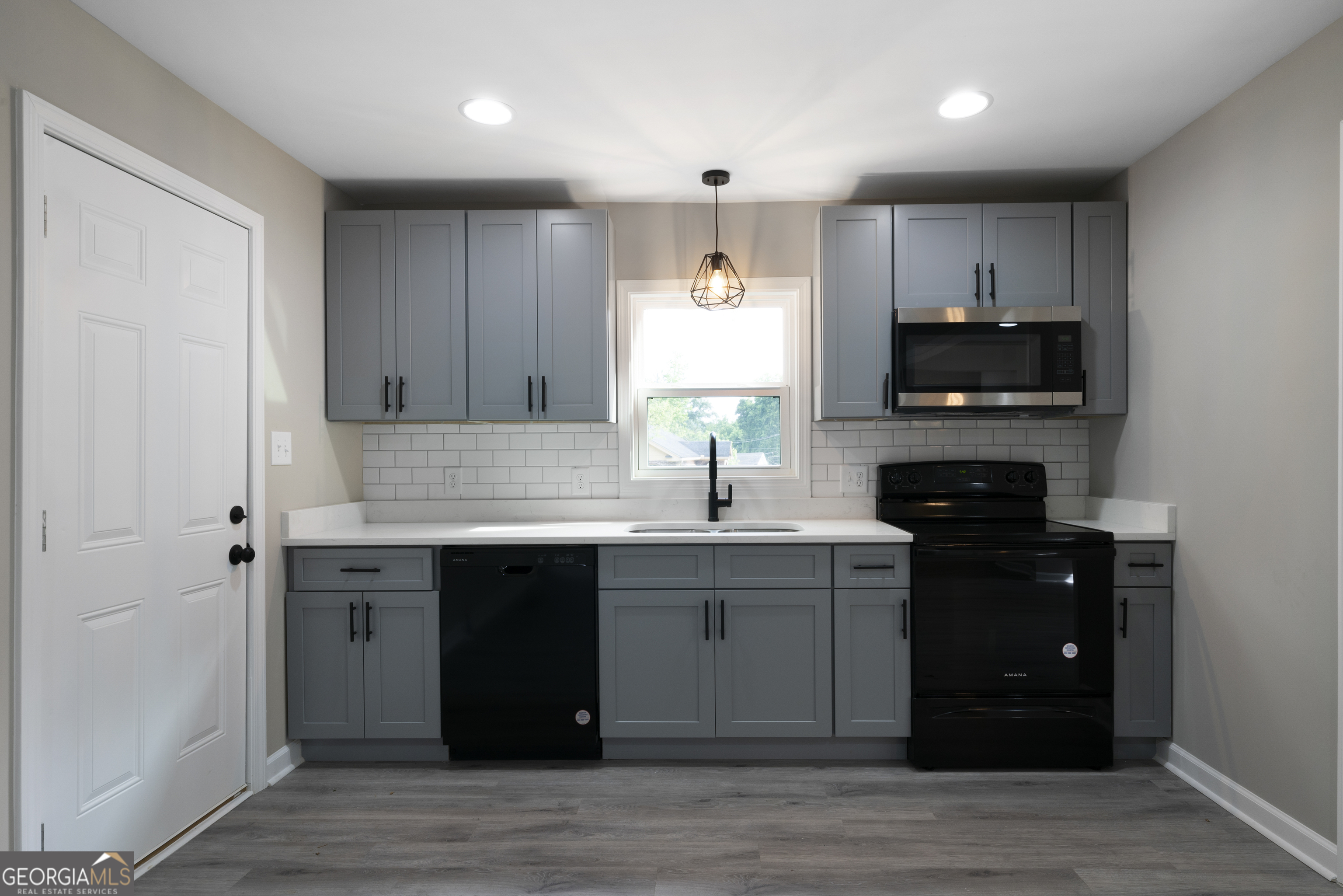 515 Harper Avenue Southwest Rome, GA 30161 - Photo 10 of 17 a kitchen with kitchen island granite countertop a sink cabinets and wooden floor