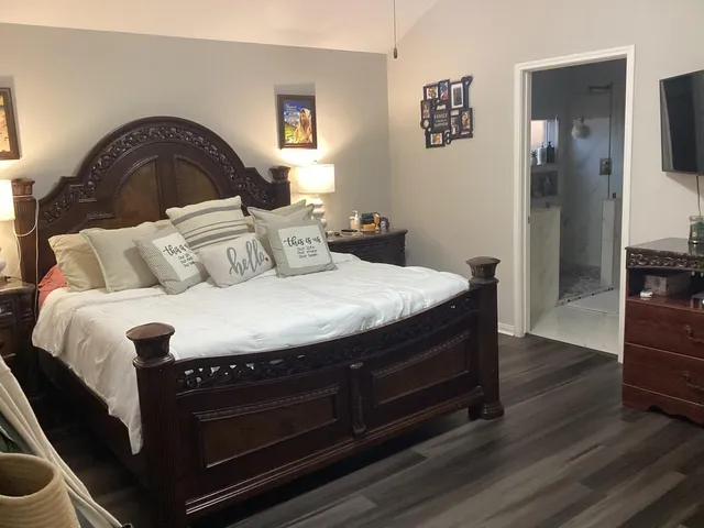 a bedroom with a bed and wooden floor
