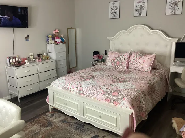 a bedroom with a bed and a tv on the dresser