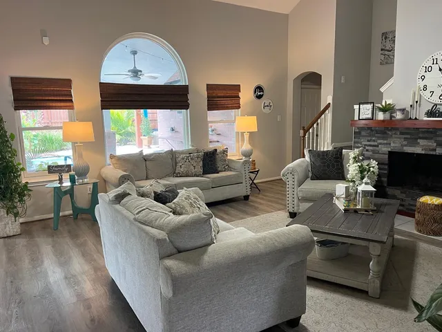 a living room with furniture a fireplace and a large window