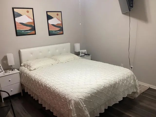 a large bed sitting in a bedroom next to a window