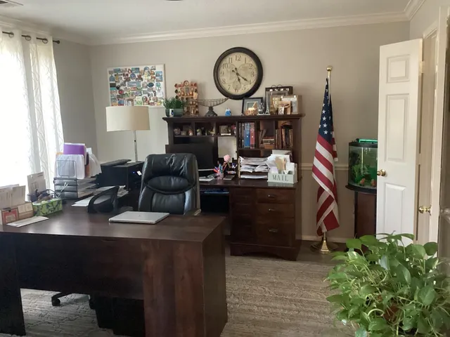 a view of a workspace with furniture and a window