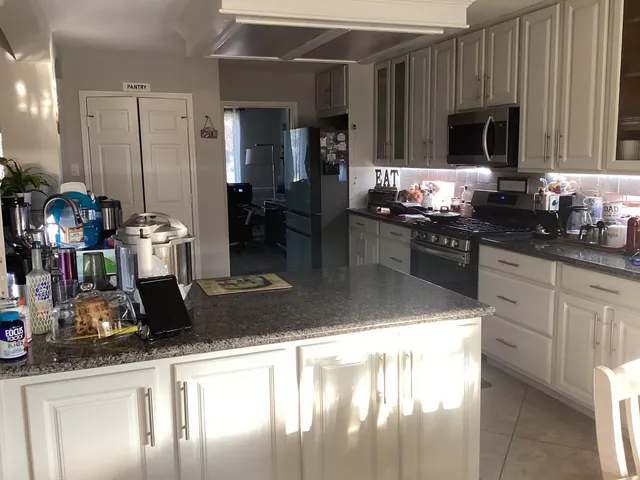 a kitchen with stainless steel appliances granite countertop a sink and a stove