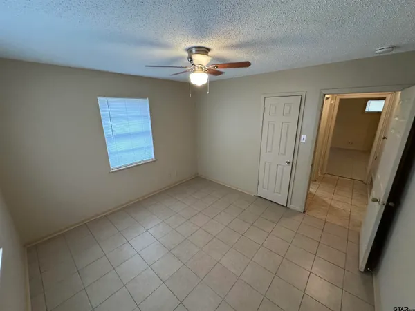 an empty room with windows and fan