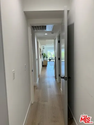 a living room with furniture a large window and wooden floor