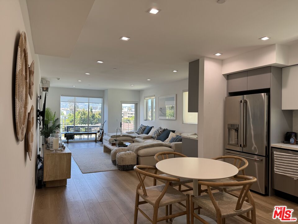 9842 Vidor Drive, Unit 402 Los Angeles, CA 90035 - Photo 17 of 23 a living room with furniture a large window and wooden floor