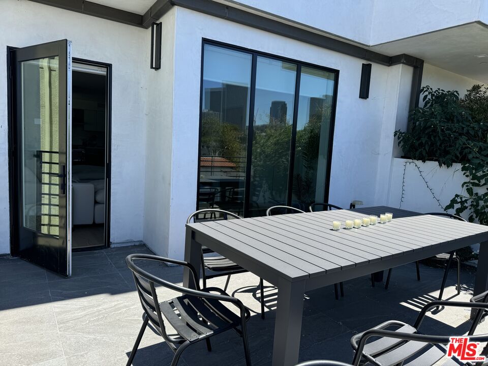 9842 Vidor Drive, Unit 402 Los Angeles, CA 90035 - Photo 22 of 23 a table and chairs sitting in front of a house