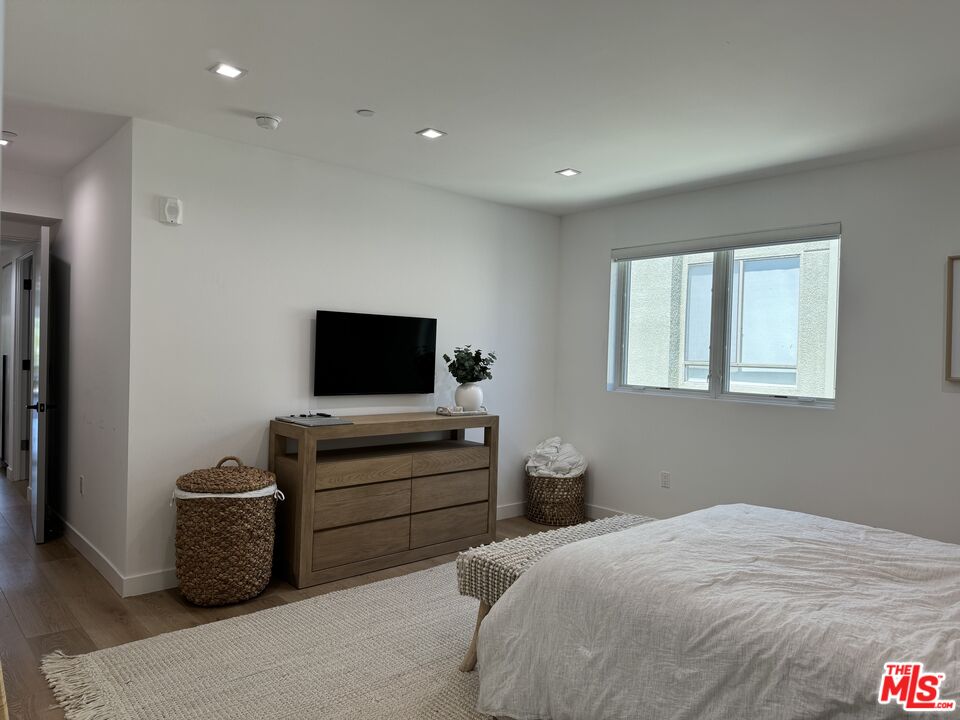 9842 Vidor Drive, Unit 402 Los Angeles, CA 90035 - Photo 9 of 23 a bedroom with a bed and a television