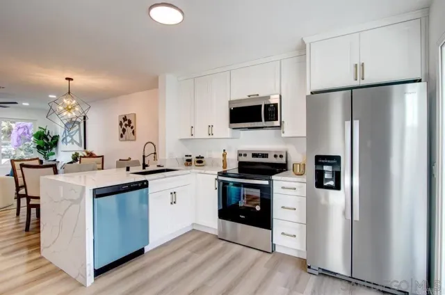 a kitchen with stainless steel appliances a refrigerator stove microwave and sink