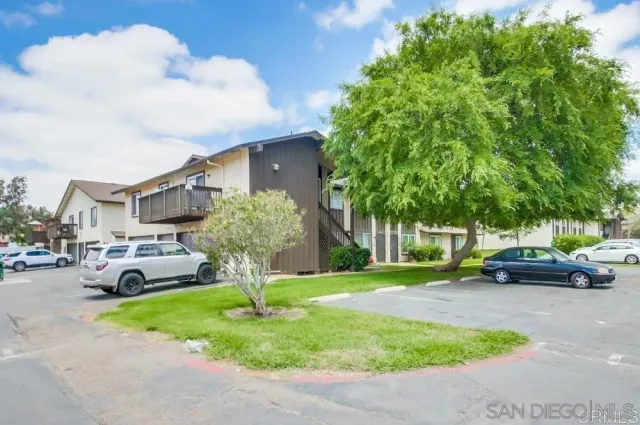 a front view of a house with garden and car parked