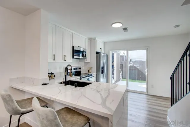 a kitchen with a table chairs sink and cabinets