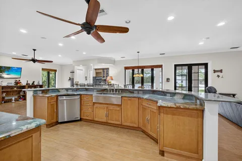 a kitchen with stainless steel appliances a dining table chairs and a wooden floor