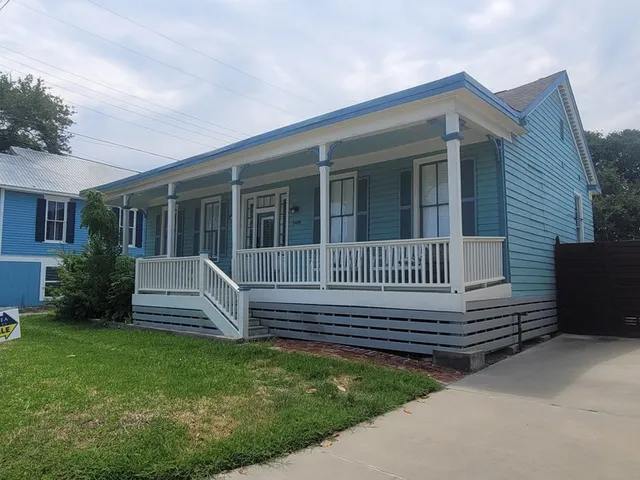 a view of a house with a small yard and wooden fence