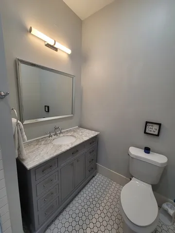 a bathroom with a granite countertop toilet sink and mirror