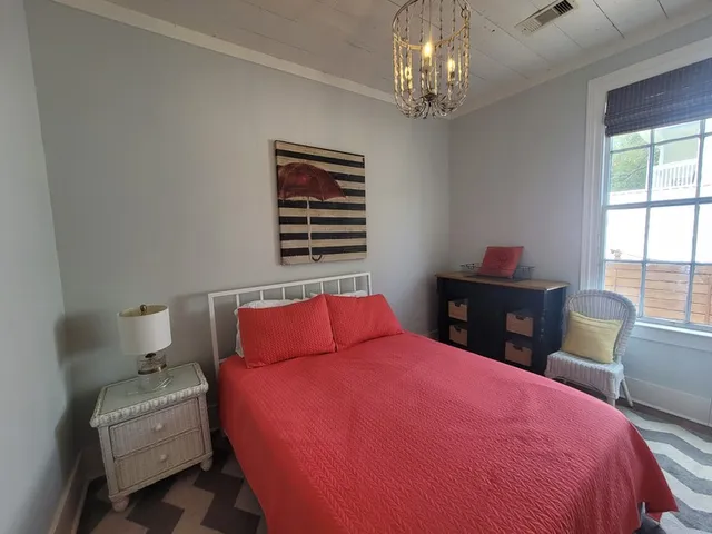 a bedroom with a bed and a chandelier