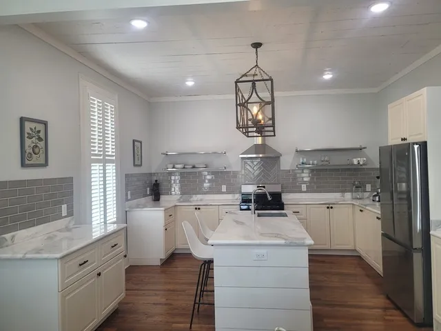 a kitchen with stainless steel appliances granite countertop a sink stove and refrigerator